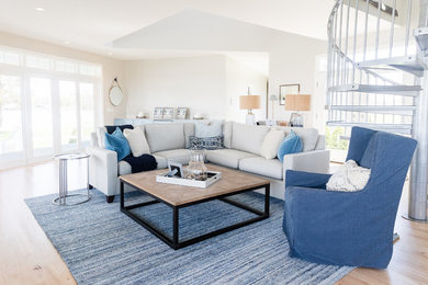 Design ideas for a beach style open concept living room in Baltimore with white walls and light hardwood floors.