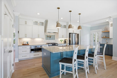 Inspiration for a large coastal l-shaped eat-in kitchen remodel in DC Metro with a drop-in sink, recessed-panel cabinets, quartz countertops, subway tile backsplash, stainless steel appliances and an island