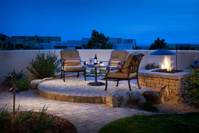 This is an example of a mid-sized backyard patio in Albuquerque with a fire feature, no cover and concrete pavers.