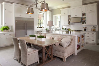 Design ideas for a large traditional u-shaped kitchen in Houston with stainless steel appliances, an undermount sink, shaker cabinets, white cabinets, granite benchtops, white splashback, subway tile splashback, porcelain floors, with island and grey floor.