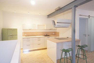 Kleine Moderne Küche mit braunem Holzboden in Sonstige
