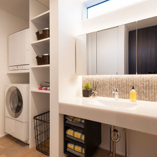Modern utility room in Other with open cabinets, white walls, painted wood flooring, a stacked washer and dryer, brown floors, white worktops and a submerged sink.