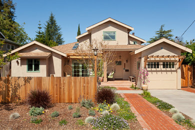 Mediterranean split-level stucco beige house exterior in San Francisco with a gable roof and a shingle roof.