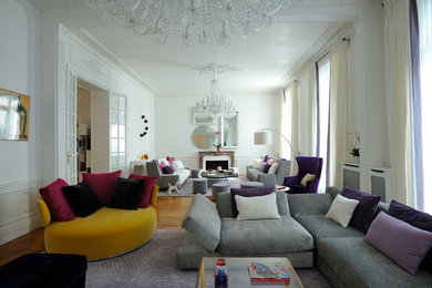 Cette photo montre un salon moderne haussmannien avec un mur blanc et parquet clair.