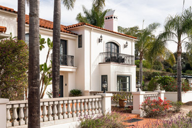 Example of a tuscan white two-story house exterior design in Santa Barbara with a tile roof and a red roof
