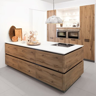 Zweizeilige, Mittelgroße Moderne Küche mit Vorratsschrank, Einbauwaschbecken, flächenbündigen Schrankfronten, hellbraunen Holzschränken, Laminat-Arbeitsplatte, Küchengeräten aus Edelstahl und Kücheninsel in Christchurch