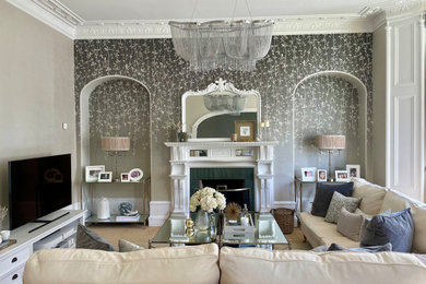 Large classic formal and grey and white open plan living room feature wall in Other with grey walls, carpet, a standard fireplace, a wooden fireplace surround, a freestanding tv, beige floors and wallpapered walls.