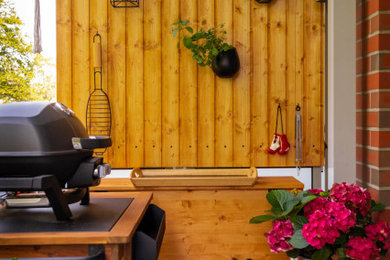 Small trendy wood railing balcony photo in Hamburg with a bbq area and a roof extension