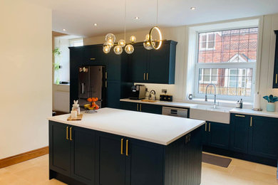 Photo of a large traditional kitchen in Other with a belfast sink, shaker cabinets, blue cabinets, quartz worktops, white splashback, metro tiled splashback, stainless steel appliances, porcelain flooring, an island, white floors and white worktops.