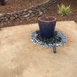 Cette image montre un xéropaysage avant traditionnel de taille moyenne avec une exposition ensoleillée, des pavés en pierre naturelle et un point d'eau.