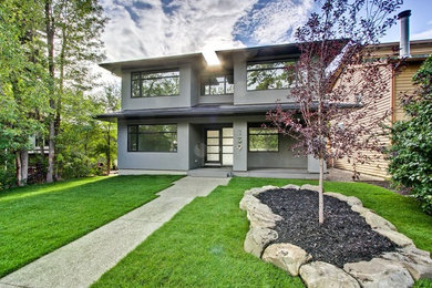 Example of a mid-sized minimalist gray two-story concrete exterior home design in Calgary