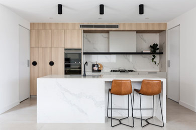 Photo of an expansive contemporary galley separate kitchen in Sydney with with island, an undermount sink, flat-panel cabinets, light wood cabinets, marble benchtops, multi-coloured splashback, marble splashback, beige floor and multi-coloured benchtop.