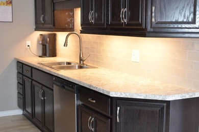 Small transitional galley vinyl floor and gray floor enclosed kitchen photo in Other with a drop-in sink, recessed-panel cabinets, dark wood cabinets, laminate countertops, glass tile backsplash, stainless steel appliances and no island