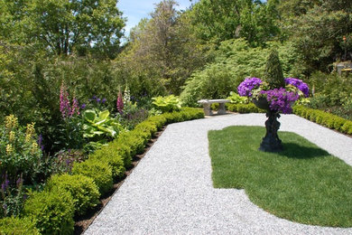 This is an example of a mid-sized traditional backyard gravel landscaping in New York.