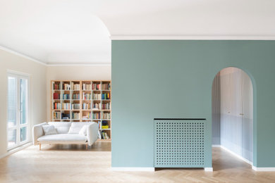 Diseño de biblioteca en casa abierta y abovedada actual extra grande con paredes verdes, suelo de madera en tonos medios y madera