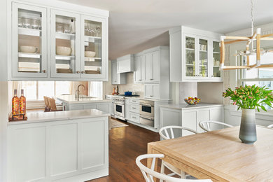 Example of a transitional kitchen design in New York with shaker cabinets, white cabinets, quartz countertops, porcelain backsplash and an island