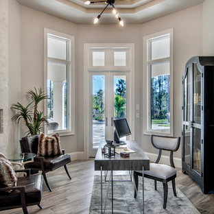 モダンスタイルのおしゃれな書斎 (白い壁、淡色無垢フローリング、自立型机、茶色い床、両方向型暖炉) の写真