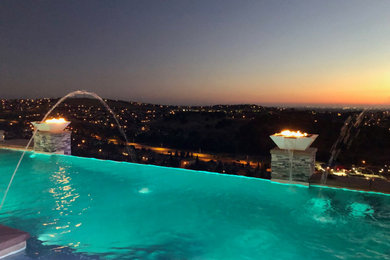 Inspiration for a huge contemporary backyard concrete and custom-shaped infinity pool remodel in Sacramento