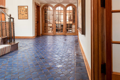 This is an example of an expansive mediterranean hallway in Minneapolis with white walls, ceramic floors and blue floor.