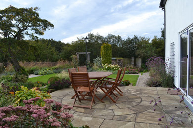 Modelo de jardín de estilo de casa de campo grande en patio trasero con gravilla