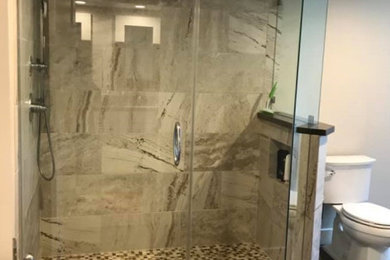 Cette image montre une grande salle de bain principale minimaliste avec une douche d'angle, WC séparés, un carrelage gris, des carreaux de porcelaine, un mur blanc, un sol en carrelage de porcelaine, un sol gris, une cabine de douche à porte battante et une niche.