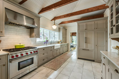 Design ideas for a mid-sized country separate kitchen in Philadelphia with a farmhouse sink, shaker cabinets, quartz benchtops, white splashback, subway tile splashback, stainless steel appliances, ceramic floors, white benchtop and vaulted.