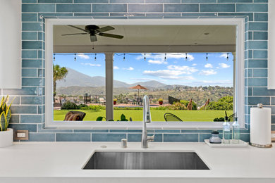 Inspiration for a transitional kitchen remodel in San Diego with an undermount sink, blue backsplash, subway tile backsplash, stainless steel appliances and white countertops