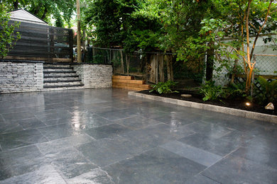 Photo of a large modern partial sun backyard stone landscaping in Toronto for spring.