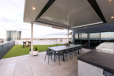 Mid-sized contemporary backyard verandah in Geelong with an outdoor kitchen, natural stone pavers and a roof extension.