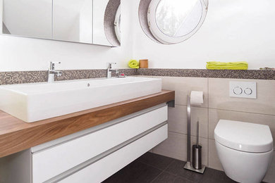 Mittelgroßes Modernes Duschbad mit weißen Schränken, Wandtoilette mit Spülkasten, weißer Wandfarbe, flächenbündigen Schrankfronten, bodengleicher Dusche, Porzellanfliesen, Waschtischkonsole, offener Dusche und weißer Waschtischplatte in Frankfurt am Main