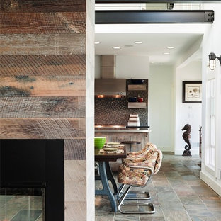 Ispirazione per un piccolo soggiorno stile marinaro aperto con pavimento in ardesia, TV a parete, pareti bianche, camino bifacciale, cornice del camino in legno e pavimento multicolore