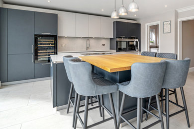 This is an example of a large contemporary kitchen in Berkshire with flat-panel cabinets, blue cabinets, quartz worktops and an island.