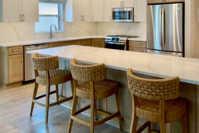Inspiration for a mid-sized transitional single-wall medium tone wood floor and brown floor kitchen remodel in Orlando with an undermount sink, shaker cabinets, medium tone wood cabinets, quartz countertops, white backsplash, quartz backsplash, stainless steel appliances and white countertops