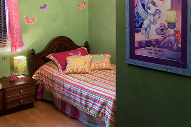 Ejemplo de dormitorio infantil moderno de tamaño medio con paredes verdes, suelo de madera clara y suelo marrón