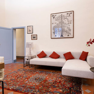 Photo of a large modern study in Florence with white walls, terracotta flooring, a standard fireplace, a concrete fireplace surround, a freestanding desk and brown floors.