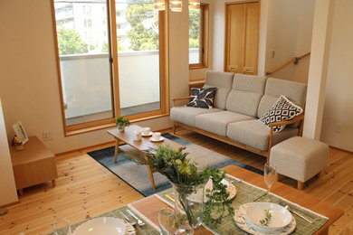 Open concept living room in Tokyo with white walls and light hardwood floors.