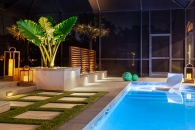 Cette image montre une terrasse arrière minimaliste de taille moyenne avec une cuisine d'été, du carrelage et une pergola.