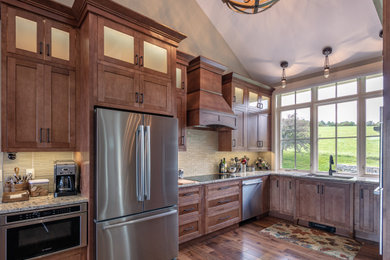 Kitchen - mid-sized transitional u-shaped medium tone wood floor, vaulted ceiling and brown floor kitchen idea in Boston with an undermount sink, recessed-panel cabinets, medium tone wood cabinets, granite countertops, glass tile backsplash, stainless steel appliances, no island, beige backsplash and multicolored countertops