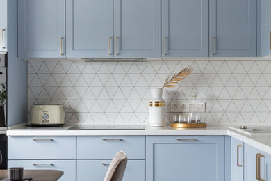 Inspiration for a transitional l-shaped kitchen in Moscow with shaker cabinets, blue cabinets, white splashback, multi-coloured floor, white benchtop and recessed.