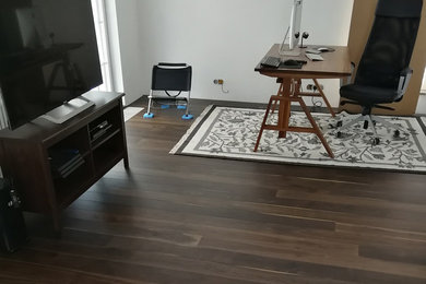 This is an example of an industrial home office in Moscow with dark hardwood floors and brown floor.