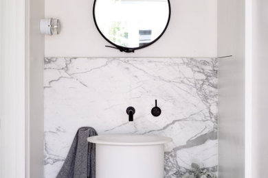 This is an example of a contemporary master bathroom in Auckland with gray tile, marble, white walls, a vessel sink and a single vanity.