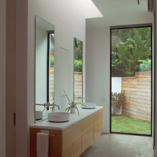 Exempel på ett mellanstort modernt vit vitt en-suite badrum, med släta luckor, skåp i mellenmörkt trä, vita väggar, betonggolv och grått golv