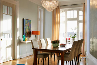 Modernes Esszimmer mit grüner Wandfarbe und braunem Holzboden in Essen