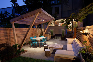 Small modern backyard partial sun garden in New York with natural stone pavers for summer.