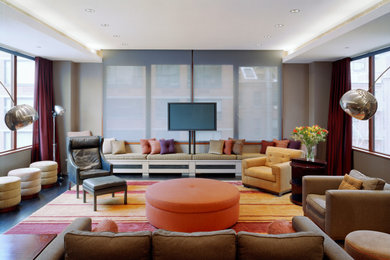 Example of a huge eclectic open concept dark wood floor and brown floor living room design in New York with gray walls and a wall-mounted tv