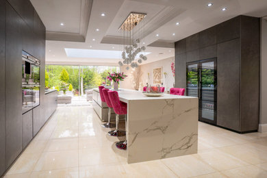 Photo of a large contemporary open plan kitchen in Berkshire with an integrated sink, flat-panel cabinets, integrated appliances and an island.