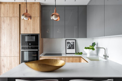 Example of a mid-sized trendy u-shaped eat-in kitchen design in Moscow with an undermount sink, flat-panel cabinets, light wood cabinets, white backsplash, an island and white countertops
