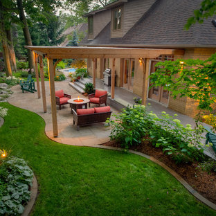 Design ideas for a large traditional backyard garden in Toronto with natural stone pavers and with lawn edging.