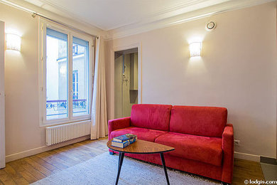 Offenes Modernes Wohnzimmer mit beiger Wandfarbe, hellem Holzboden und braunem Boden in Paris