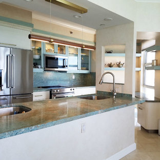 Exemple d'une arrière-cuisine parallèle éclectique de taille moyenne avec un évier encastré, un placard à porte vitrée, des portes de placard turquoises, un plan de travail en granite, un électroménager en acier inoxydable, un sol en marbre, un îlot central, un sol beige et un plan de travail turquoise.